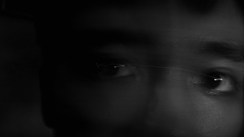 Intriguing black and white close-up of a person's eyes conveying mystery and depth.